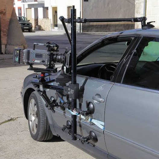 Cámara de cine montada con ventosas y tubos en el lateral de un coche